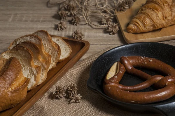 Vari pane appena sfornato sul tavolo di legno — Foto Stock