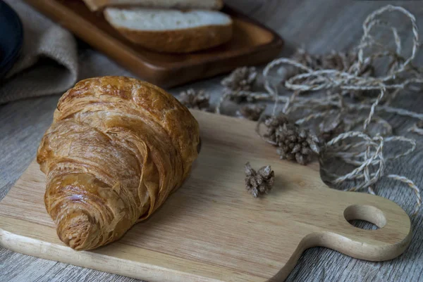 Frische Croissants auf einem Holzschneidebrett — Stockfoto