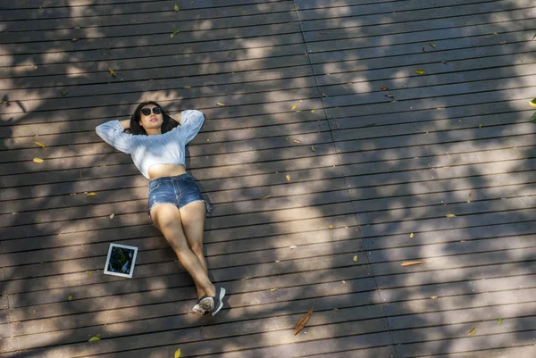 La chica se sentó en la tableta mientras estaba sentada en el jardín . — Foto de Stock