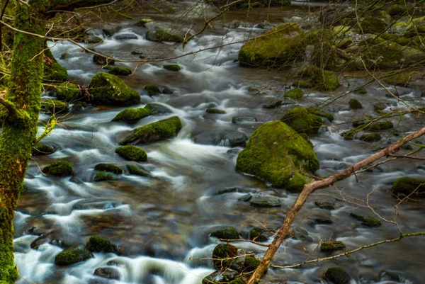 El agua que fluye a través de las rocas cuesta abajo creando un pequeño wate — Foto de Stock