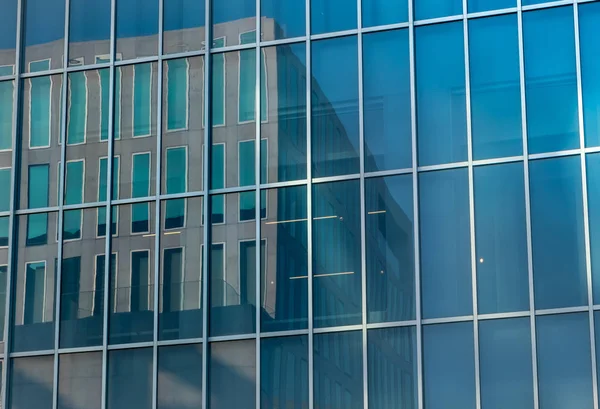 Edifício refletido na parede fachada de vidro do edifício . — Fotografia de Stock