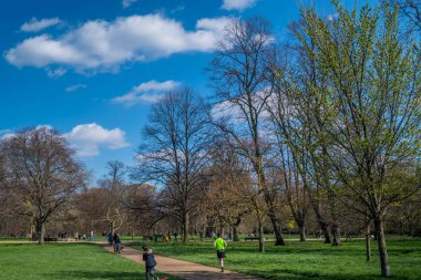 İnsanlar güzel bir günde Hyde Park'ta dinlenmek için geliyorlar..