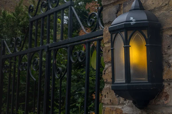Lampy oświetlają wieczór dołączony do domu. — Zdjęcie stockowe