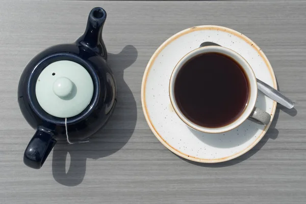 Xícara de chá com bule em uma mesa de madeira . — Fotografia de Stock