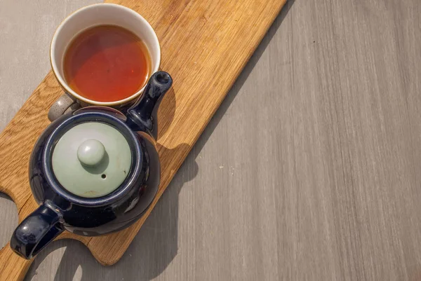 Csésze tea teáskanna egy fából készült asztal. — Stock Fotó