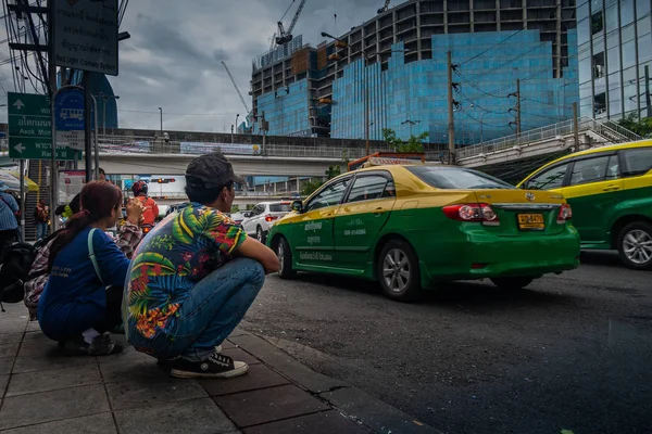 Jeunes hommes et femmes attendant le bus sur la route Khlong Toei . — Photo