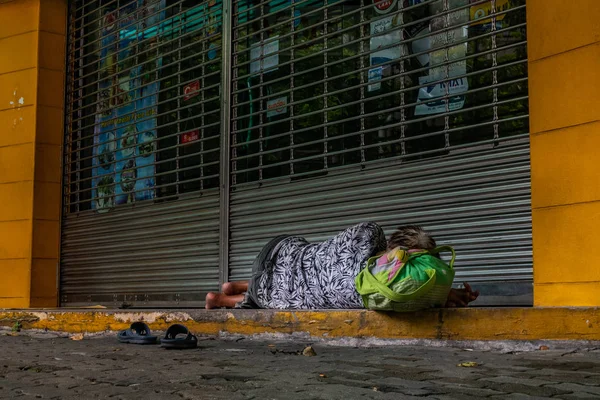 Dakloze blote voeten vrouw slapen op de stoep voor t — Stockfoto