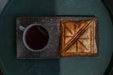 Kahvaltı-sandviç ve fincan çay seramik tepsi üzerinde. 