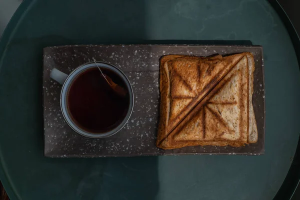 Śniadanie-Kanapki i filiżanka herbaty na taca ceramiczny. — Zdjęcie stockowe