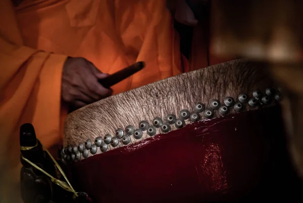 Mão de monge budista tocando um tambor para pagar respeito por Budas — Fotografia de Stock