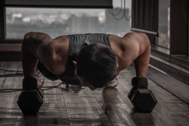 Spor salonunda ya da Fitnes 'te halterle şınav çeken yakışıklı kaslı adam.