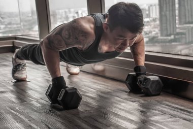 Spor salonunda ya da Fitnes 'te halterle şınav çeken yakışıklı kaslı adam.