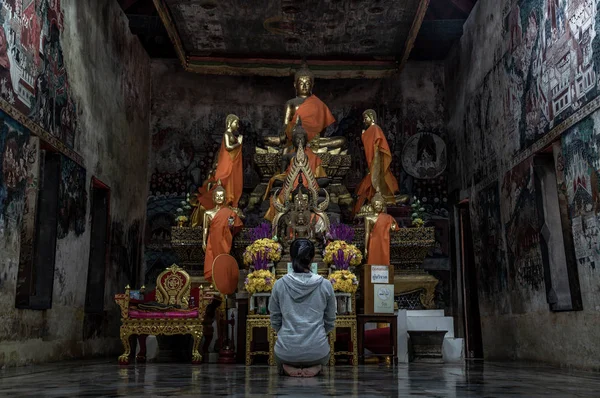 Ung kvinna sitter ber betala respekt för Buddha staty i — Stockfoto