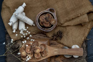 Tahta kepçe ve çuval bezinde kahverengi kamış şeker küpü. Seçici odaklanma. Üst görünüm.