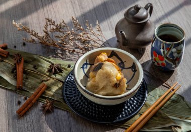 Çin usulü pirinç köfteleri (Zongzi) Çin çayı ile servis edilen kase Çin usulü yemek çubukları ve yapraklarla sarılmış piramit şeklinde piramitler. Ejderha teknesinde (duan wu) ünlü Asyalı lezzetli el yapımı yemek festivali vesilesi.