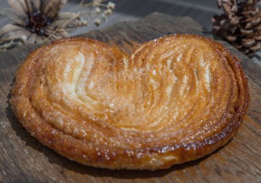 Tereyağlı Palmier ekmeğinin yakın çekimi, palmiye yapraklı Fransız pastası ya da kelebek şekli bazen domuz kulağı ya da ahşap tahta üzerinde fil kulağına benzer. Seçici odak.