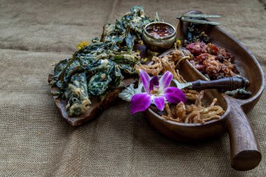 Çıtır çiçekler, çıtır çıtır otlar ve ahşap tepside tatlı soslu çıtır sebzeler, üstten belirsiz manzara, uzay kopyası..