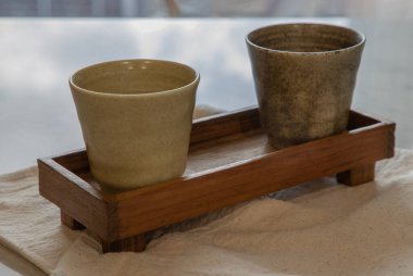 Oturma odasının mermer masasında el yapımı iki seramik kupası. Ev dekoru. Mesaj için yer var. Tam olarak odaklanamıyorum..