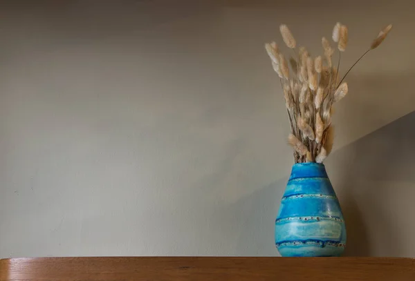 挂在客厅墙壁上的木制架子上的漂亮陶瓷蓝色花瓶里的干花 家居装饰 文字空间 有选择的重点 — 图库照片