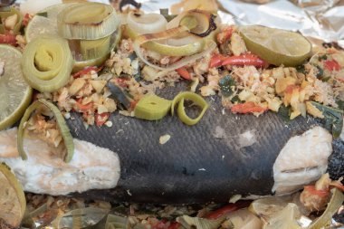 Biftek kökü, zencefil kökü, Ginger, Galangal, Kaffir limonu, Leek ve somon balığının üzerine dilimlenmiş limon dilimlenmiş kuş gözü biberi içeren fırınlanmış somonun yakın çekimi. Sağlıklı beslenme, duvar kağıdı, poster ve boşluk olarak kullanın..