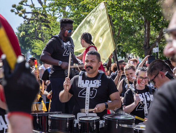London, UK - Aug 25, 2025 -  "Jesus '25" music group wearing a black T-shirt playing a set of drums to participate and celebrate their faith through music and performance in the Notting Hill Carnival. use it as your Wallpaper, Poster and Copy space, 