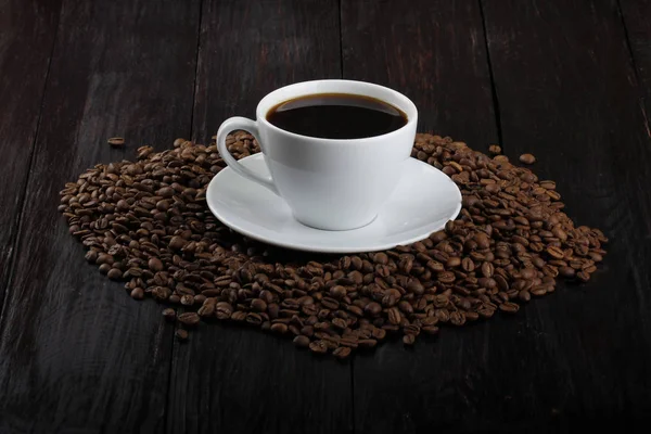 kavrulmuş kahve çekirdekleri ve fincan espresso yığını 