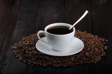 kavrulmuş kahve çekirdekleri ve fincan espresso yığını 