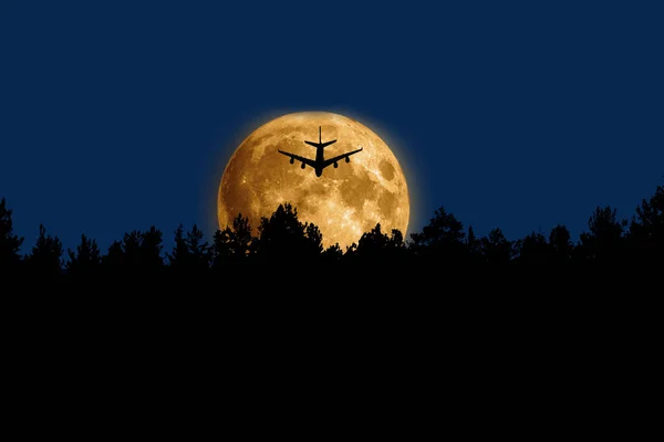 Flying airplane on full moon background