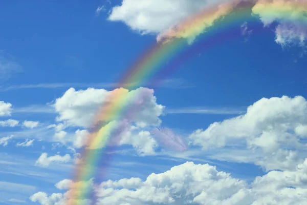 blue sky with white clouds and rainbow