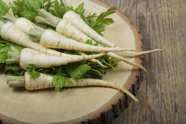 ahşap yüzeyüzerinde yaprakları ile maydanoz kökleri