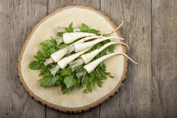 ahşap yüzeyüzerinde yaprakları ile maydanoz kökleri