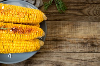 Izgara mısır, ahşap bir tabakta haşlanmış mısır. Vejetaryen yemeği, sağlıklı yemek.