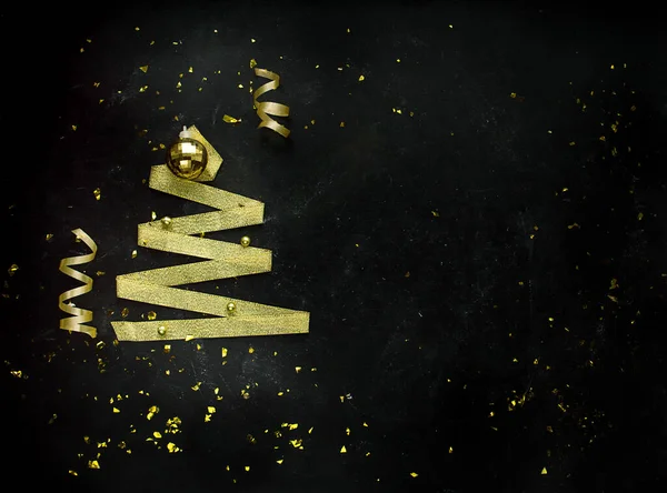 Christmas Holidays Background in gold color on a black background.Winter holidays, New Year.Flat lay, top view, copy space. Banner.Golden Streamers With Sparkling Glitter