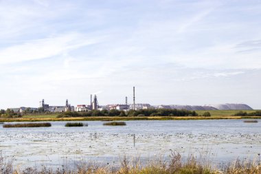 Endüstri ve vahşi yaşam. Madencilik endüstrisi. Doğa ve teknolojinin birleşimi. Yağ madenciliği. Potasyum tuzunun çıkarılması. Beyaz Rusya. Salihorsk. Nehrin arka planındaki maden..