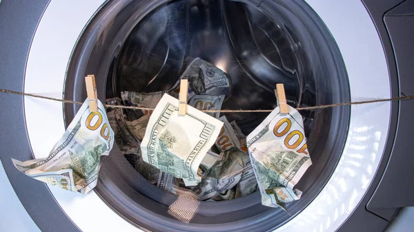 Money laundering. Corruption Concealment of taxes. Dollars in the drum of a washing machine. Concept for social advertising.