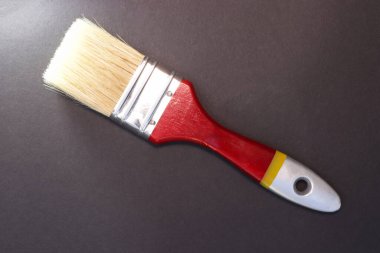 Boya fırçası. Yüzey boyası. İş aleti. Siyah eğimli arka plan. Metin için alanı kopyala.