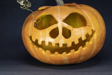 Siyah arka planda Cadılar Bayramı için balkabağı. Balkabağına oyulmuş yüz. Kutlama. Azizler Günü.