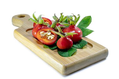 Tahta bir bambu tahtasının üzerinde gül üzümü. Doğal doğal vitaminler. Çay için malzemeler. İlaç ve sağlık