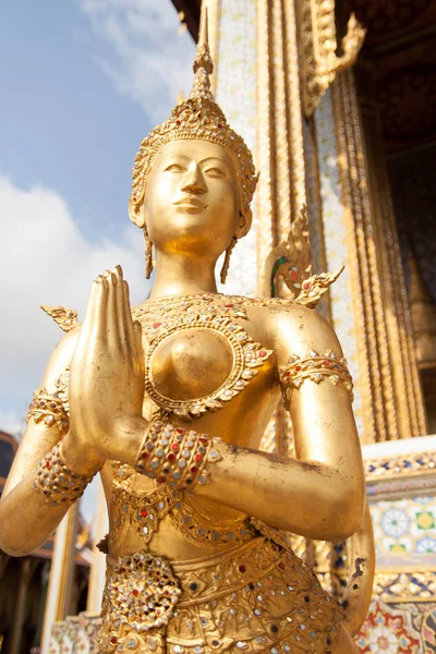 Golden Kinnari statue at Temple of Emerald Buddha (Wat Phra Kaew) in Grand Royal Palace. Kinnari is half-bird, half-woman creature at south-east Asian Buddhist mythology. Wat Phra Kaew is popular famous tourist attraction in Bangkok, landmark of Thai