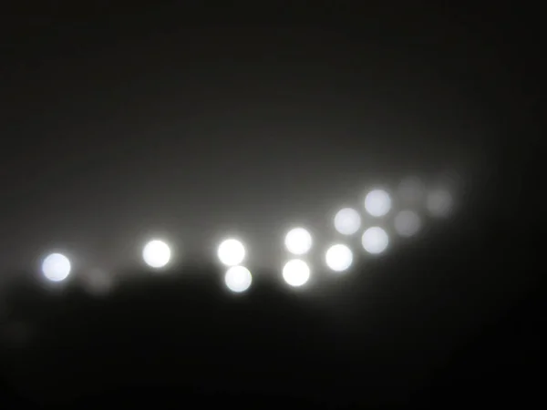 Sisteki soyut ışıklar. Sisteki bir sokak lambasından gelen parlak beyaz ışık. siyah beyaz — Stok fotoğraf
