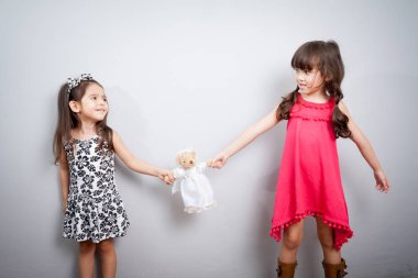 girl fight. the conflict between two sisters. the kids are fighting over a toy clipart