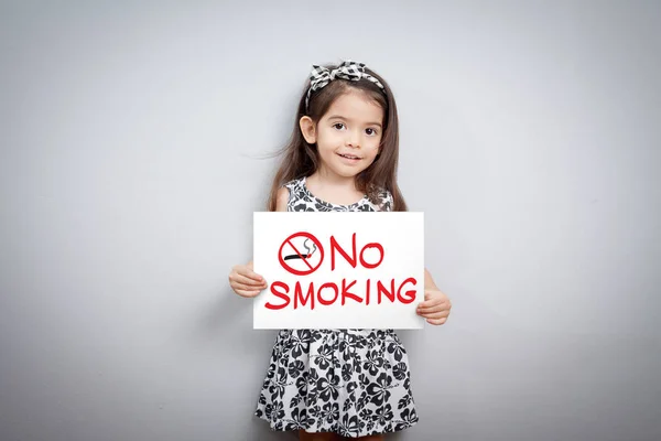 Little cute girl with handwriting text no smoking on white paper. no smoking sign. stop smoking symbol. stop smoking. quitting from addiction concept. — Stock Photo, Image