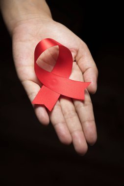 Kadın insan elinde kırmızı kurdele farkındalık : Dünya aids gün saten kurdele sembolik kavram endişeleri yükselterek / Hiv Std kalp hastalığı insanların sağlık halk desteği yardım kampanyası