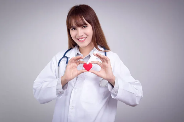 Zdrowa koncepcja: młody azjatycki lekarz z czerwonym sercem w ręku — Zdjęcie stockowe