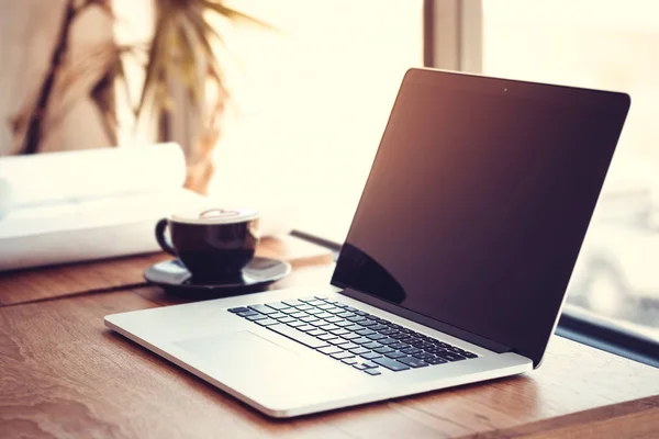 Escritório local de trabalho com laptop na mesa de madeira contra as janelas. — Fotografia de Stock