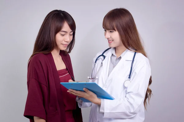 Dokter Asia perempuan memegang formulir aplikasi saat berkonsultasi dengan pasien — Stok Foto
