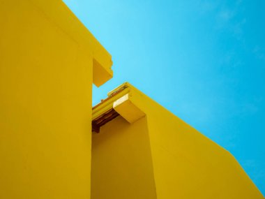 Soyut arka plan için açık mavi gökyüzü ile iki sarı bina