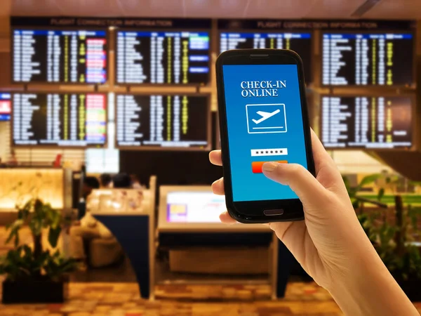 Conceito de aplicativo smartphone viajante. Close up of woman hand in international airport use mobile phone for check-in online with flight information board background, verificando seu voo. Rosto anónimo — Fotografia de Stock