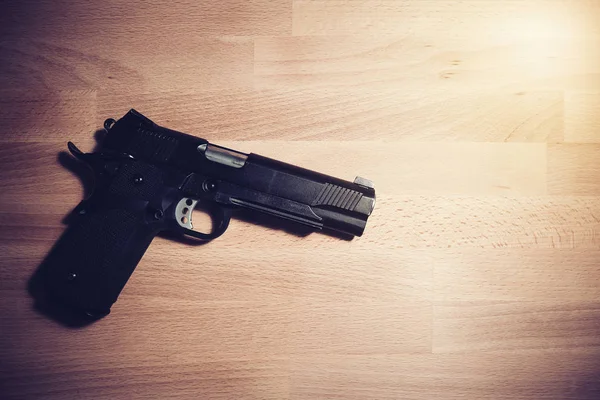 Concepto de seguridad: pistola negra sobre una mesa de madera — Foto de Stock