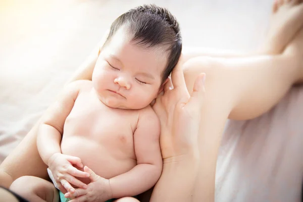 Concepto de amor y relación familiar: cerca del recién nacido lindo pequeño ojo de bebé asiático cerca se siente cómodo para dormir en la mano de la madre joven en casa, vista superior. Asia bebé retrato . — Foto de Stock